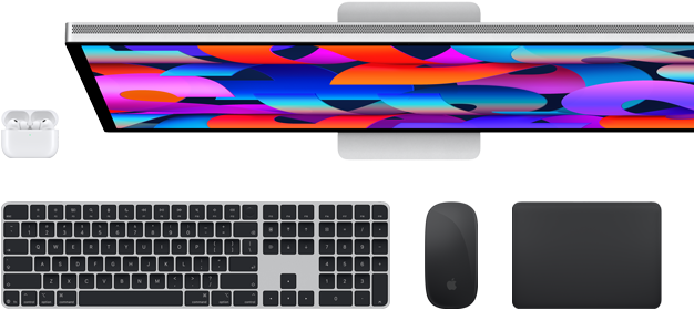 Kolekce příslušenství a zařízení včetně AirPodů, Magic Keyboardu s Touch ID, Magic Mouse, Magic Trackpadu a Studio Displaye