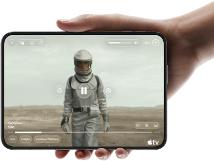 Úplně otevřený iPhone Duo, jedna ruka ho drží na šířku, na vnitřní obrazovce je snímek ze seriálu Apple TV „Silo“